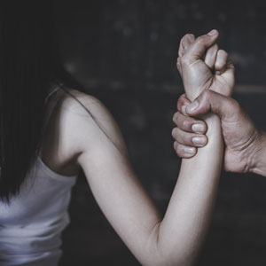 A man holding a woman's hand as she is being restrained, depicting a scene related to sex crimes. - Law Offices Of Anakalia Kaluna Sullivan